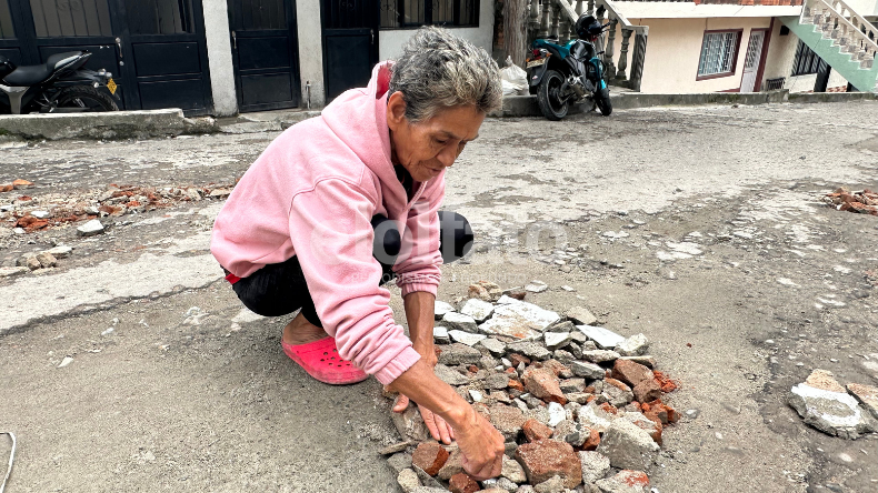 Con sus propias manos una señora en Ibagué decidió tapar los huecos de una calle