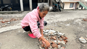 Con sus propias manos una señora en Ibagué decidió tapar los huecos de una calle